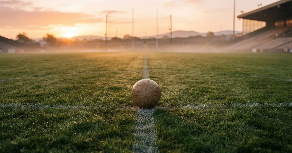A ball on the centre spot of a grass pitch in morning light