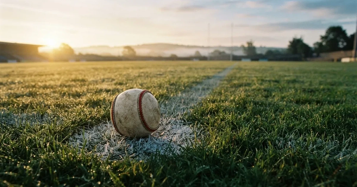 A ball on the centre spot of a grass pitch in morning light