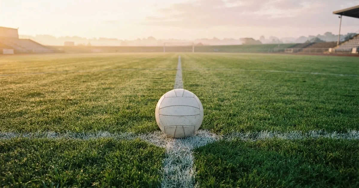 A ball on the centre spot of a grass pitch in morning light
