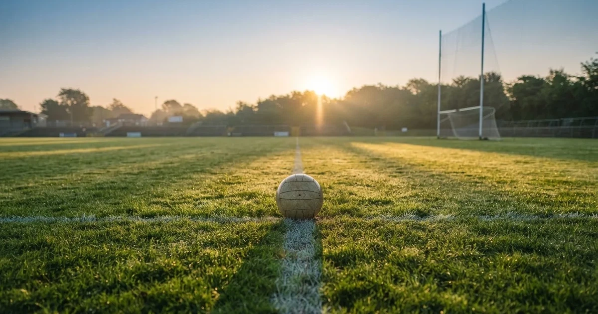 A ball on the centre spot of a grass pitch in morning light